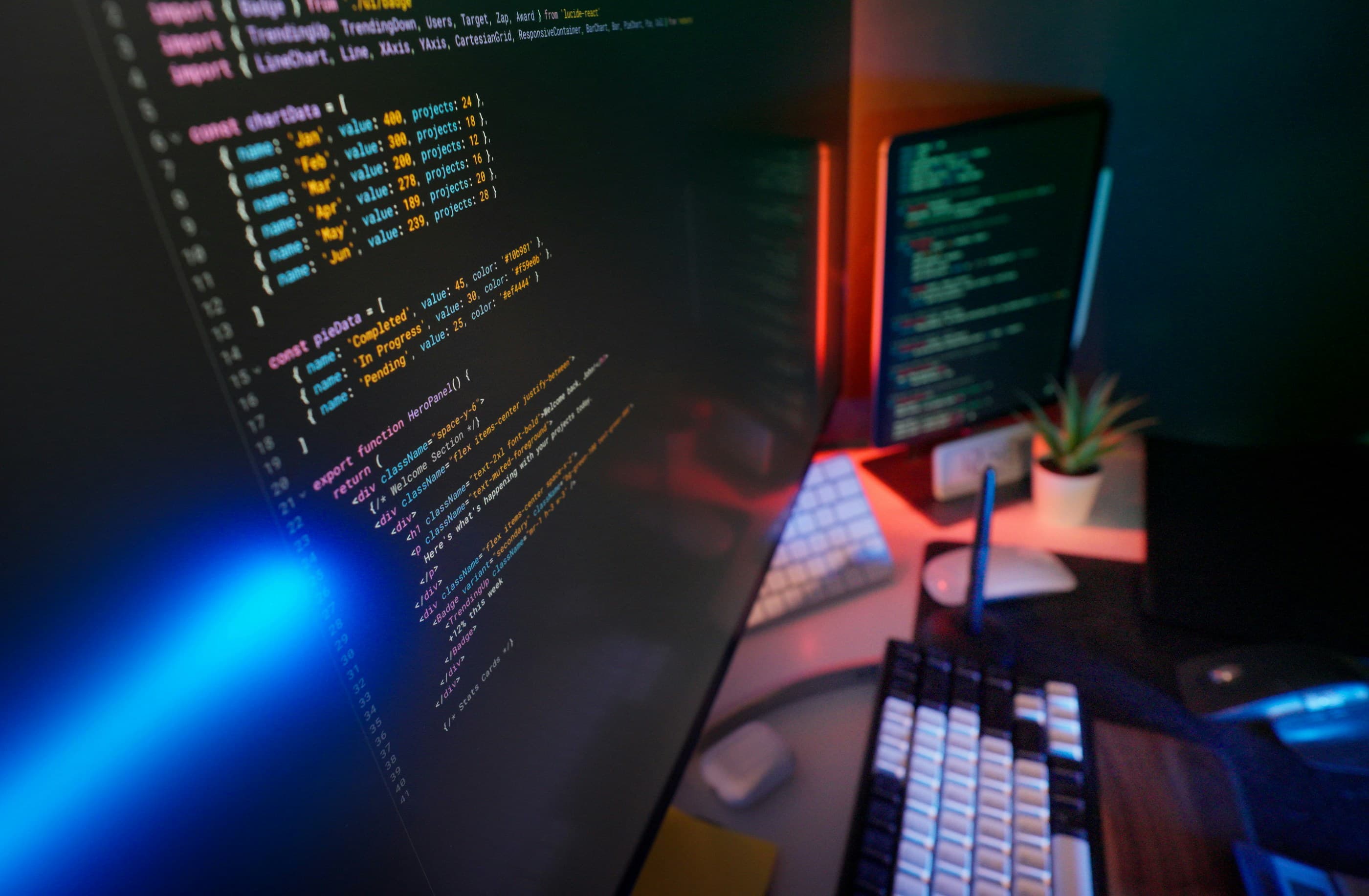 Techniczny workspace software house z kodem na wielu monitorach
